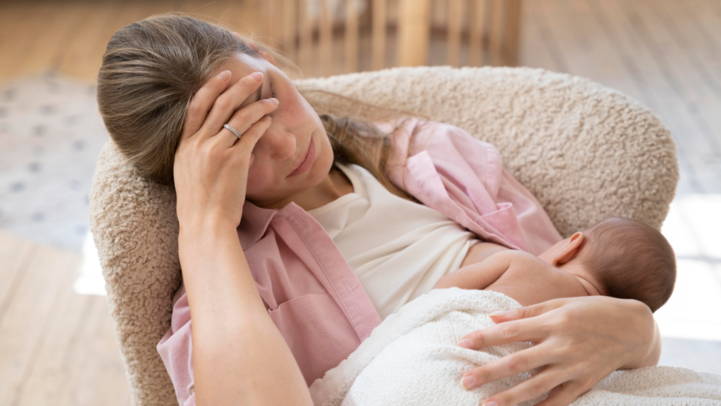 Mãe amamentando, com rosto triste, possivelmente sofrendo de depressão materna