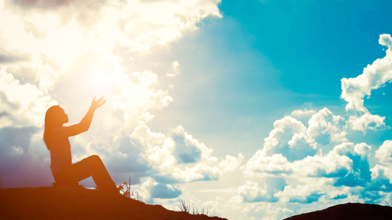 Moça orando no monte, para falar sobre como a fé pode ajudar as pessoas