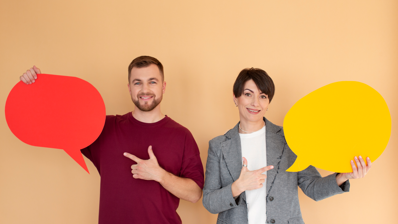 Homem e mulher sorrindo e segurando balóes de fala, para explicar os 4 pilares da comunicação assertiva