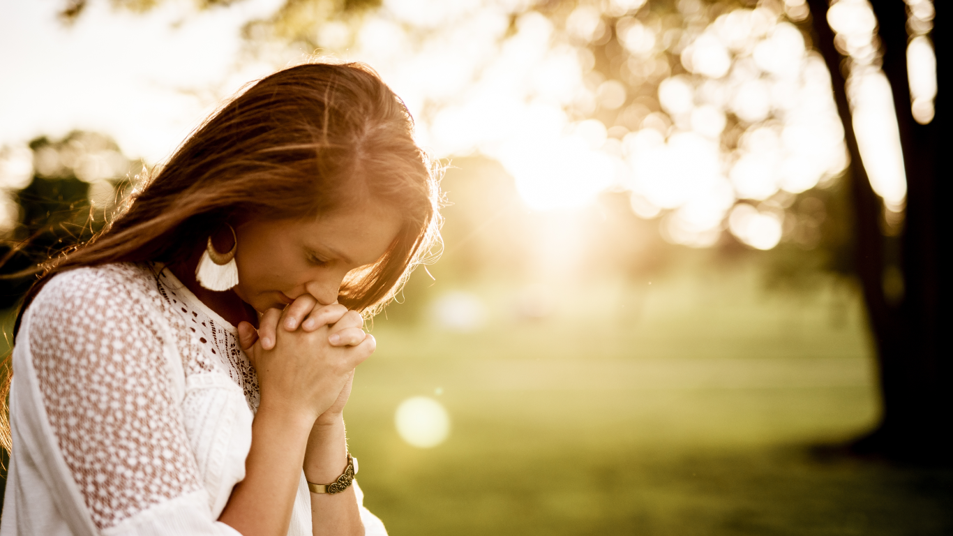 Mulher orando, sofrendo com o esgotamento espiritual